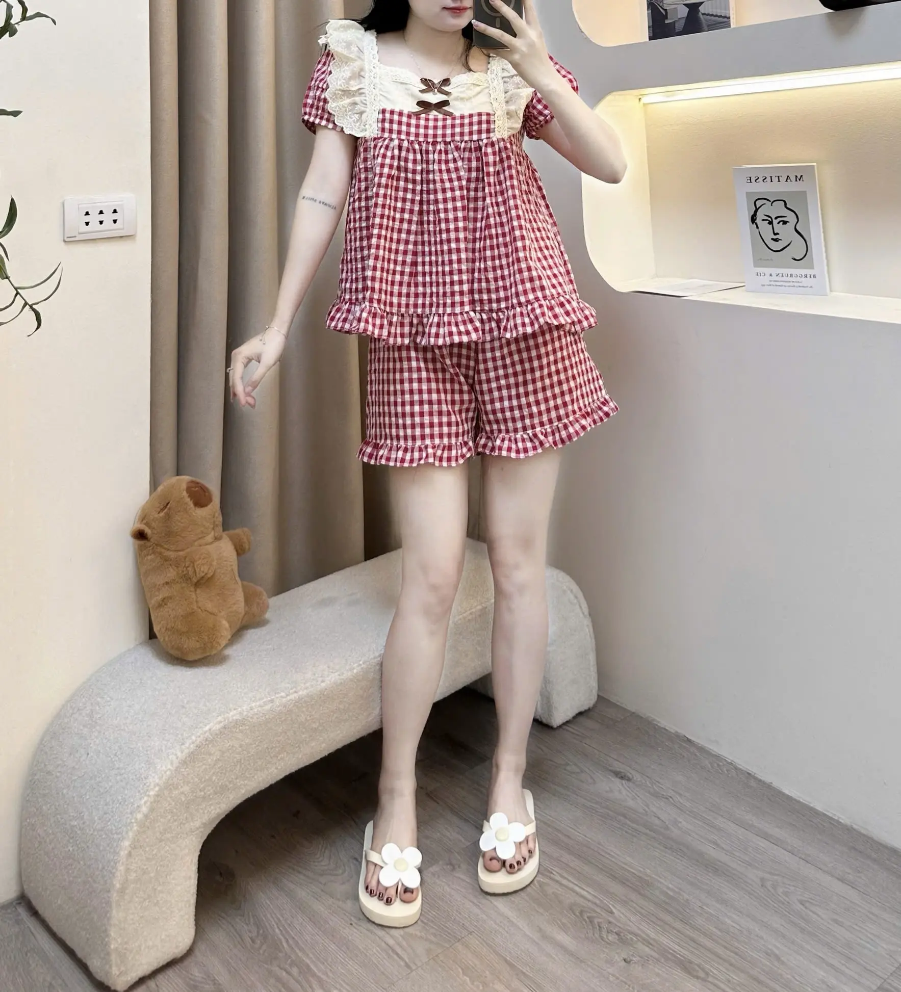 Bộ đồ ngủ mặc nhà nữ Hh áo cộc tay bồng cồ vuông cao  phối viền bèo vai Ren bản to chính giữa ngực đính 2 chiếc nơ dáng áo baby xoè rộng quần cộc hoạ tiết kẻ caro chất liệu đũi hàn mềm êm mát