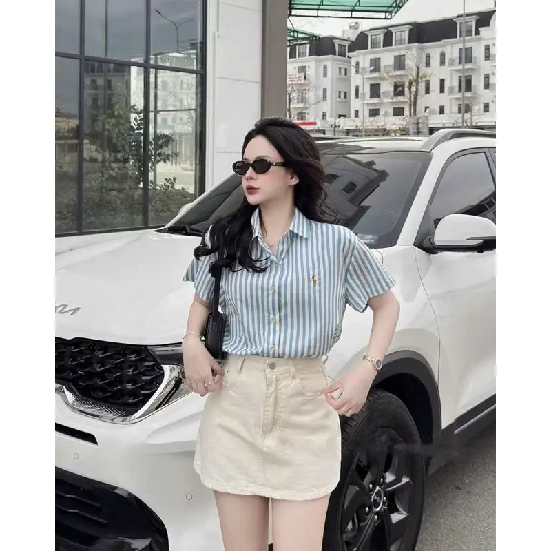 Áo Sơ Mi Nữ Ngắn Tay Kẻ Sọc Xanh Trắng Thêu Nhân Mã – Form Rộng, Thoáng Mát, Dễ Phối Đồ