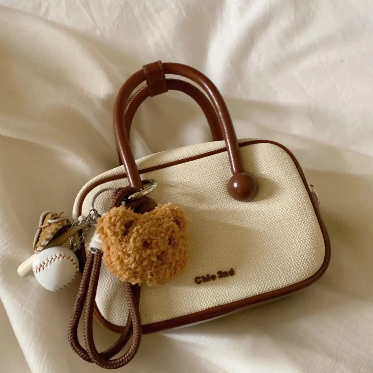 yixiaaa Túi trống chio đeo chéo kèm charm bóng chày ss thu đông Bag Nữ Đeo Vai Kem