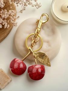 Un llavero de diseño de cereza a la moda y lindo, decoración para bolsa, uso diario, también es un pequeño regalo sorprendente y exquisito.