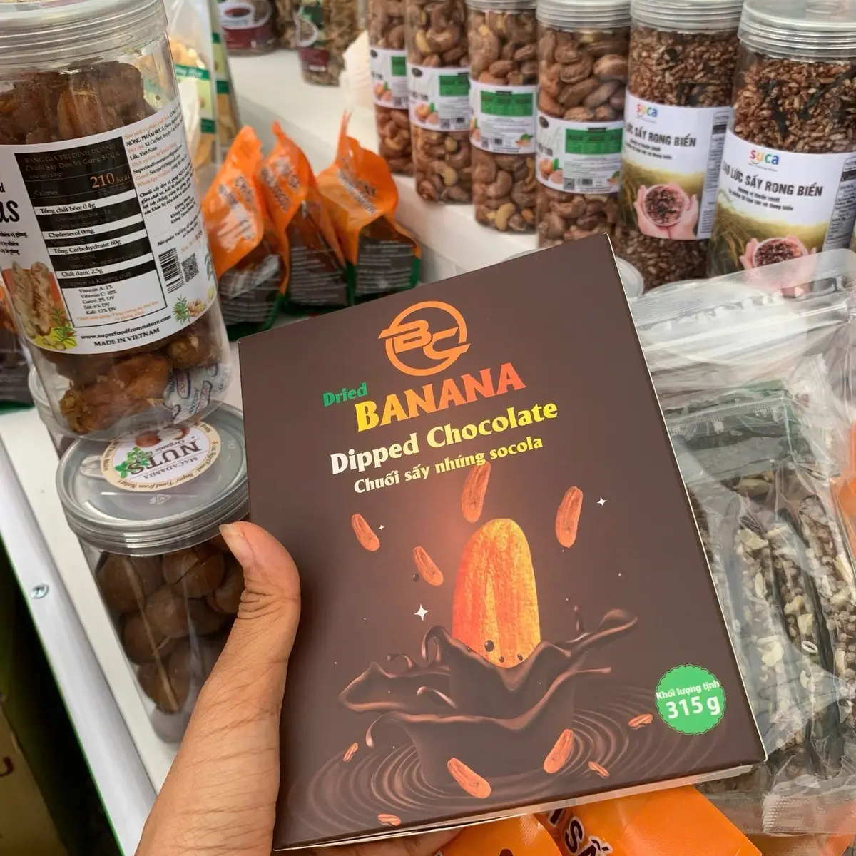 Chuối sấy dẻo nhúng sô-cô-la. Giữ hương vị tự nhiên và dinh dưỡng trọn vẹn của chuối Snack Food Ăn Vặt Nho Đường Hộp 500gr