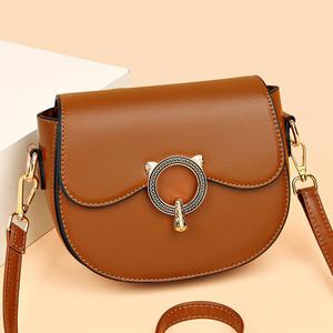 A lady's crossbody bag decorated with a cat head pattern, with detachable shoulder strap, available in various colors, and a large capacity for carrying.