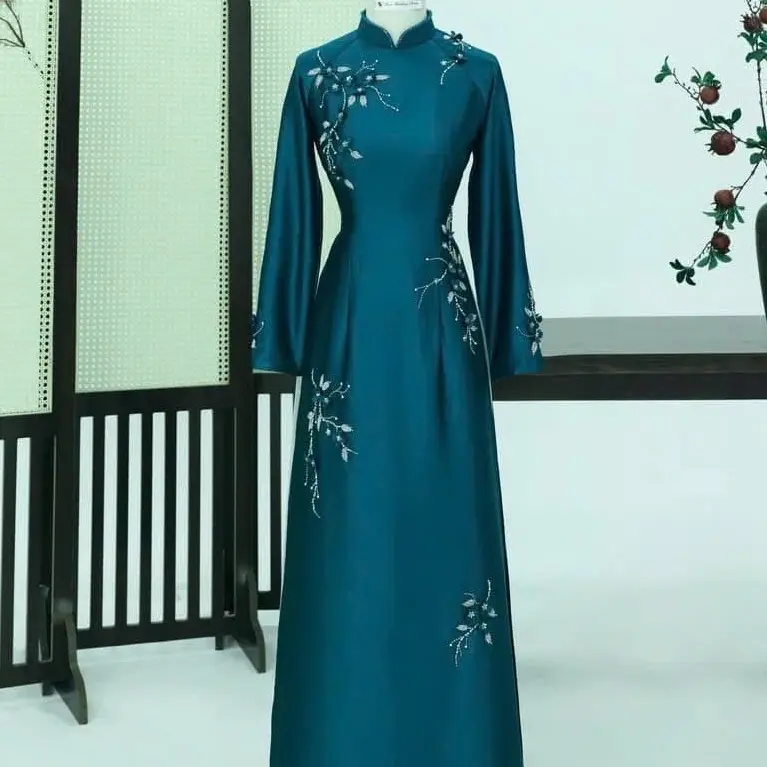 Áo dài lụa tô châu cao cấp,(màu tối hơn ảnh)thiết kế dáng ôm cổ cao tay dài sang trọng,đính kết hoa tỉ mỉ,nổi bật.Áo dài sui,áo dài mẹ